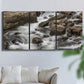 Three-panel canvas wall art featuring rushing river water over rocks, displayed in a living room above a sofa.