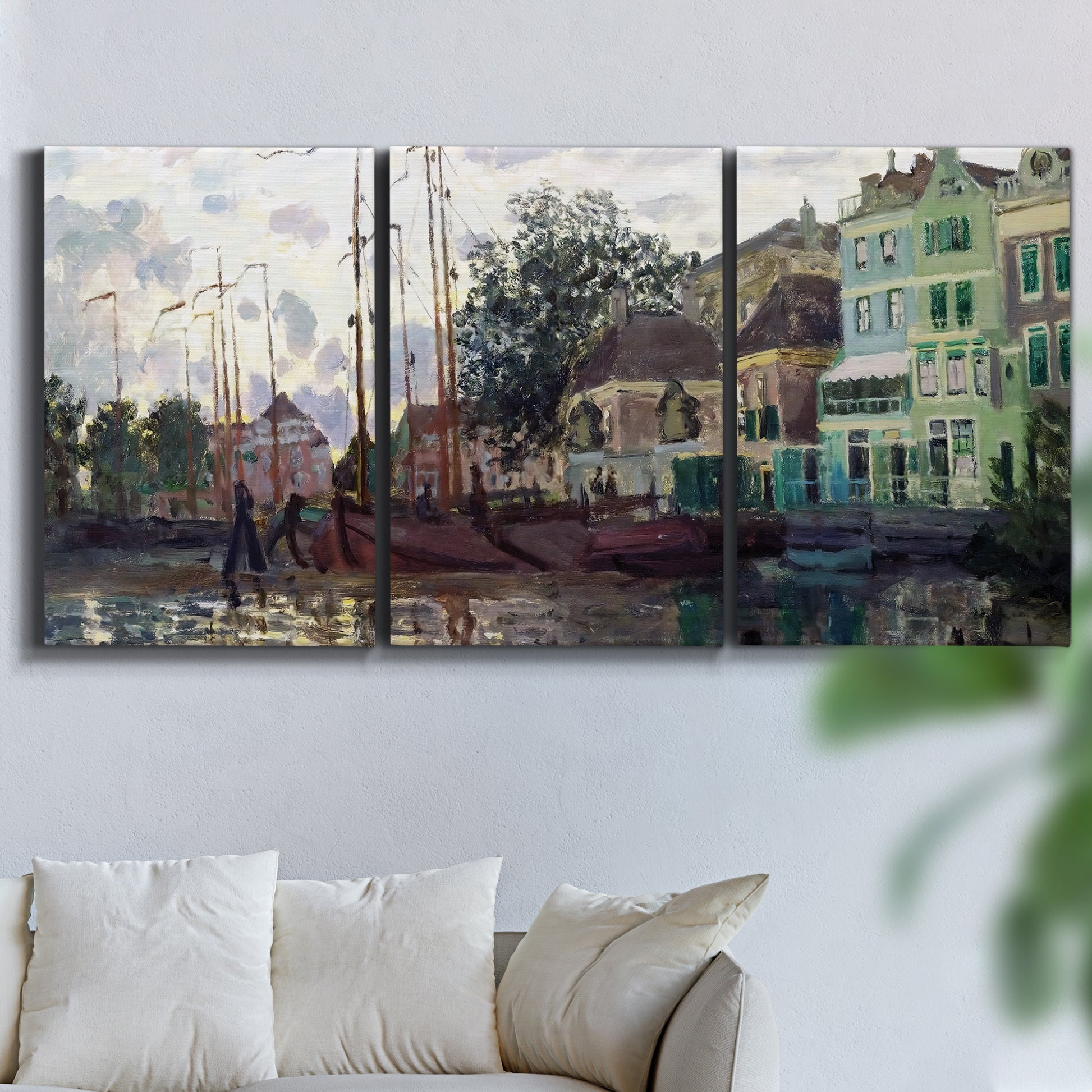 Three-panel canvas wall art featuring riverside town dike at evening, displayed in a living room above a sofa.