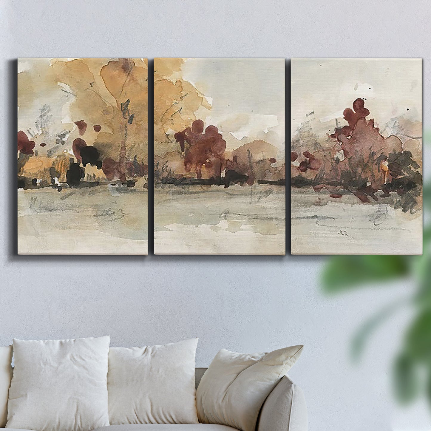 Three-panel canvas wall art featuring autumn landscape with trees and field, displayed in a living room above a sofa.