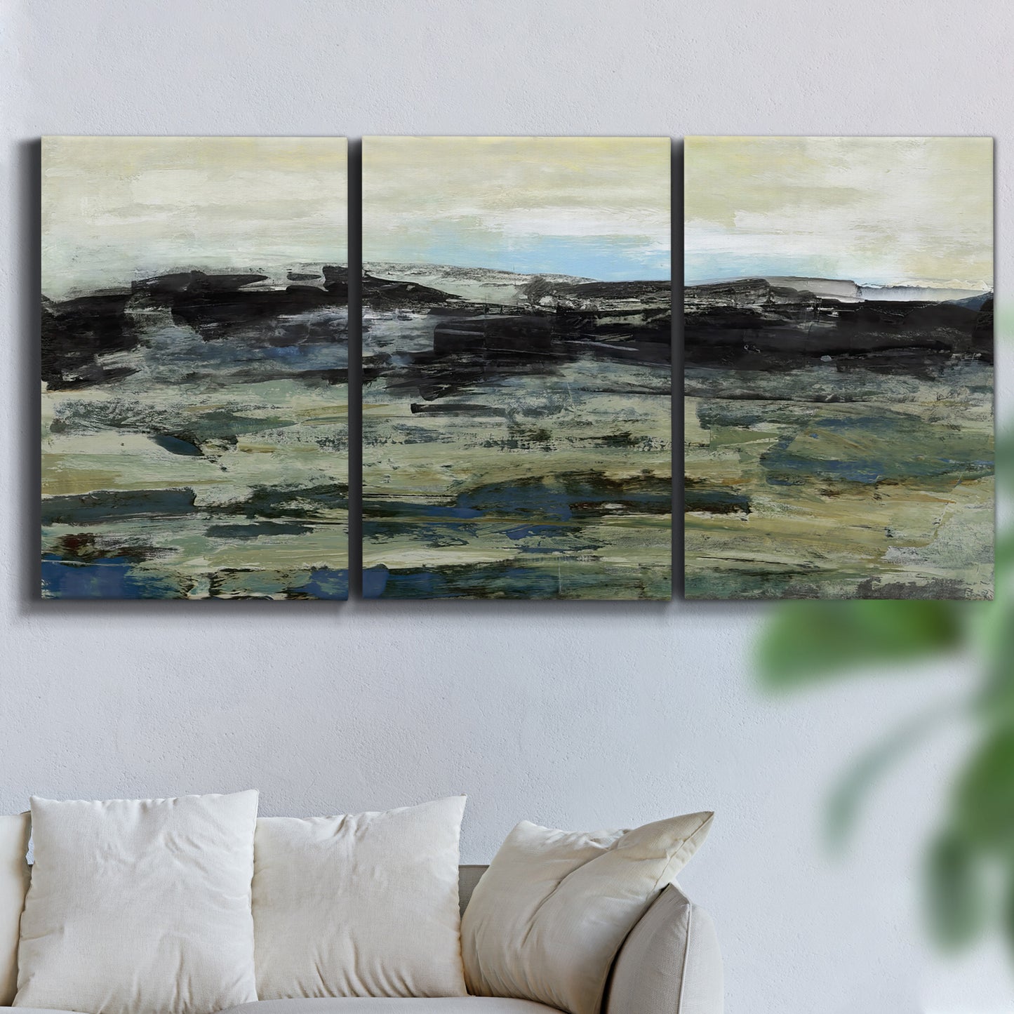Three-panel canvas wall art featuring muted abstract landscape study, displayed in a living room above a sofa.