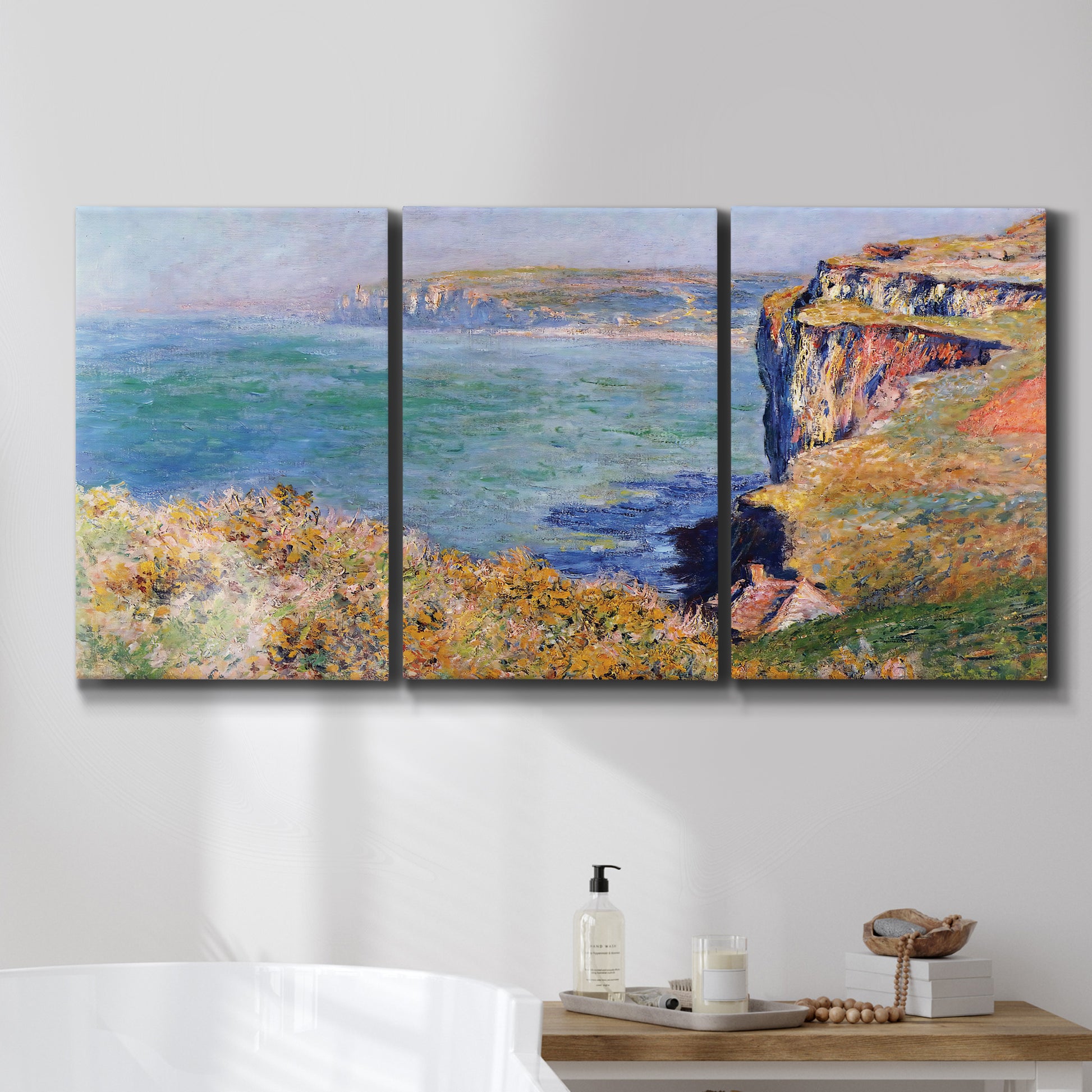 Three-panel canvas wall art featuring coastal village view near dieppe, displayed in a bathroom above a bathtub.
