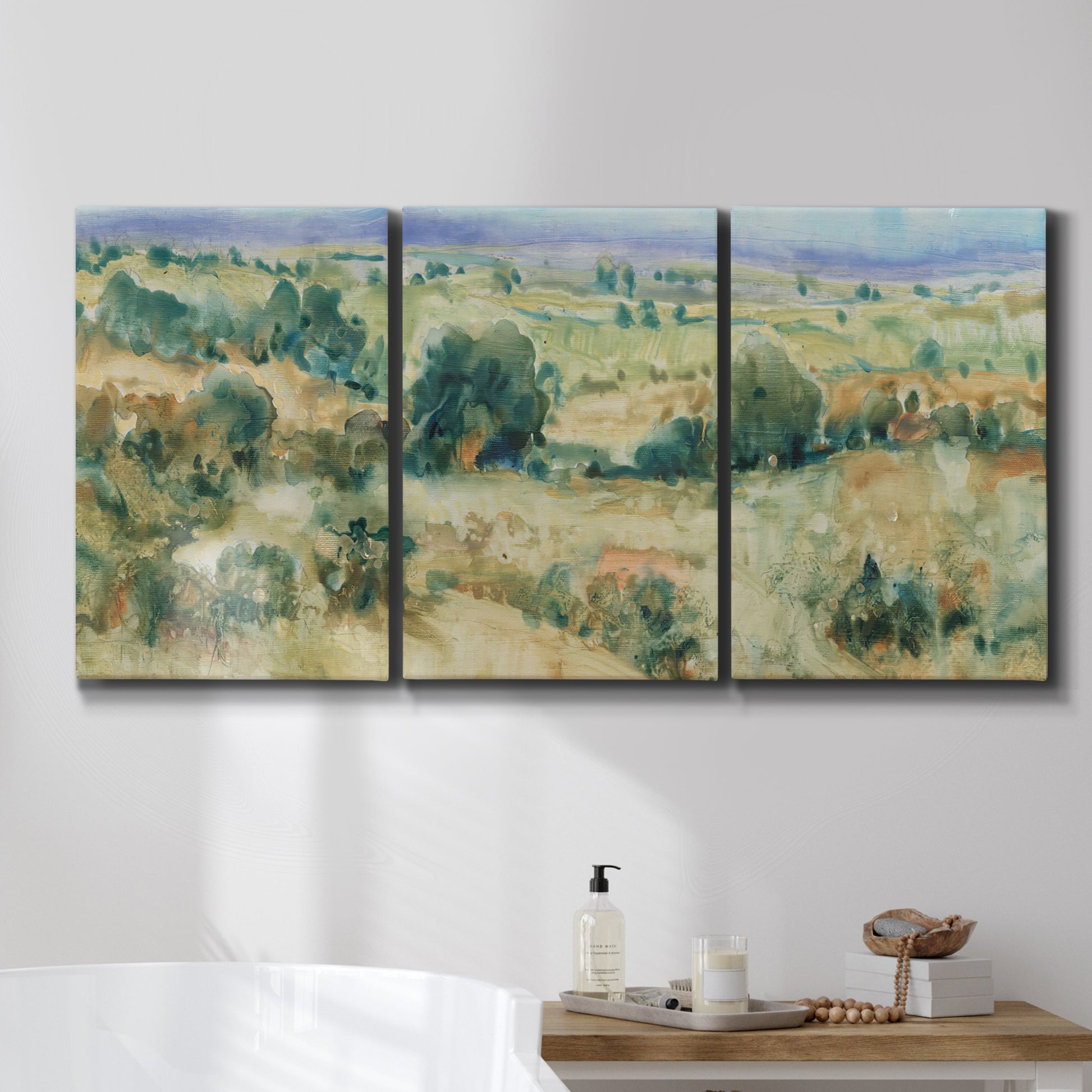 Three-panel canvas wall art featuring lavender sky over quiet landscape, displayed in a bathroom above a bathtub.