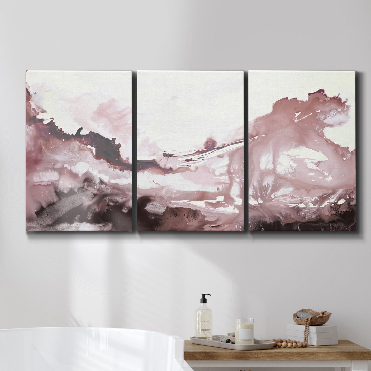Three-panel canvas wall art featuring soft pink abstract scenic layers, displayed in a bathroom above a bathtub.