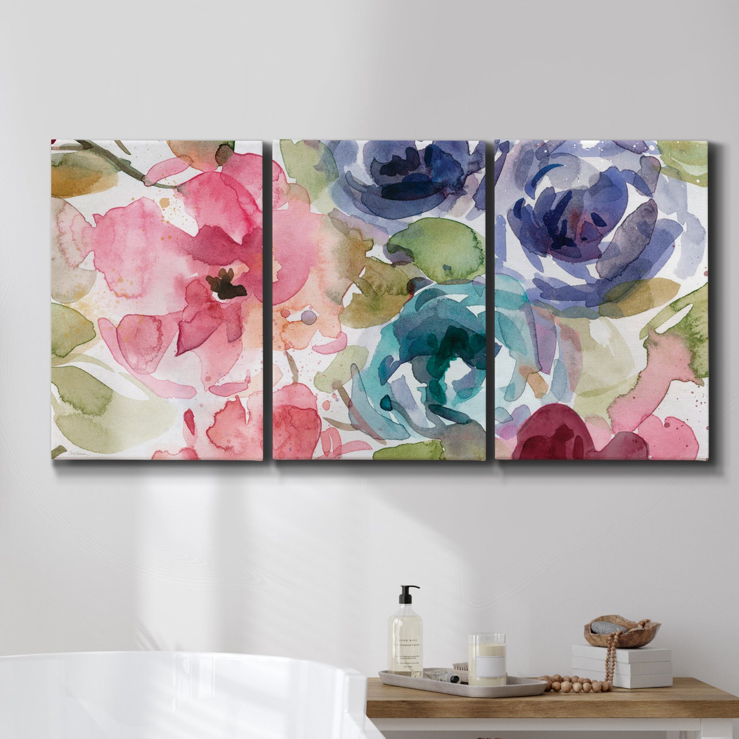 Three-panel canvas wall art featuring soft floral watercolor composition, displayed in a bathroom above a bathtub.