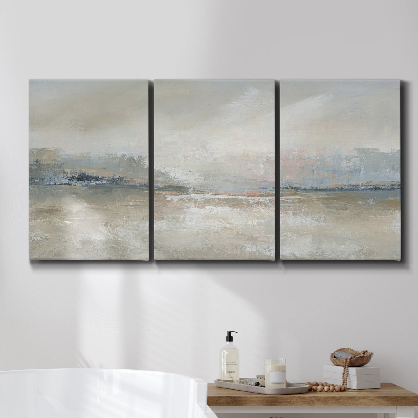 Three-panel canvas wall art featuring soft abstract horizon haze, displayed in a bathroom above a bathtub.