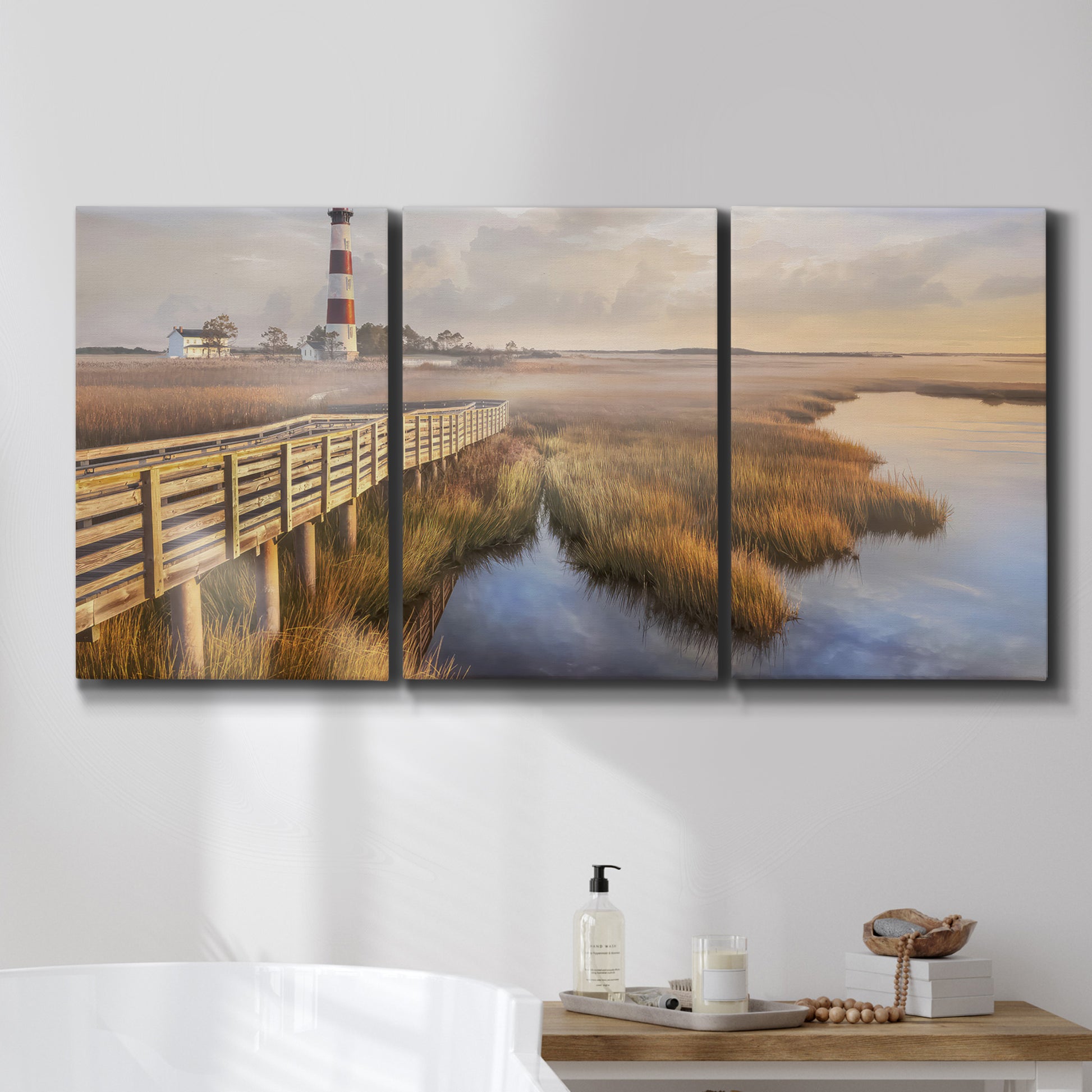 Three-panel canvas wall art featuring coastal path along dunes, displayed in a bathroom above a bathtub.
