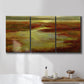 Three-panel canvas wall art featuring coastal shoreline with warm light, displayed in a bathroom above a bathtub.