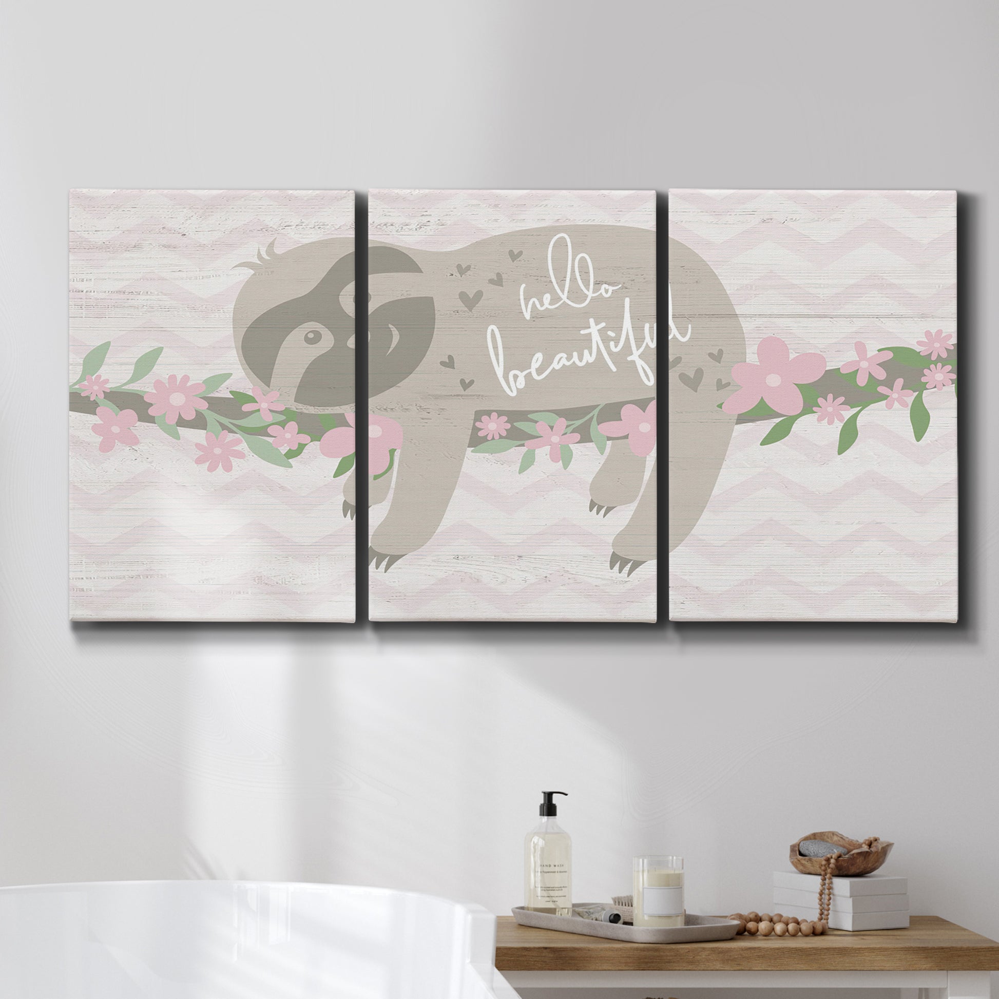 Three-panel canvas wall art featuring sloth with floral decorative elements, displayed in a bathroom above a bathtub.