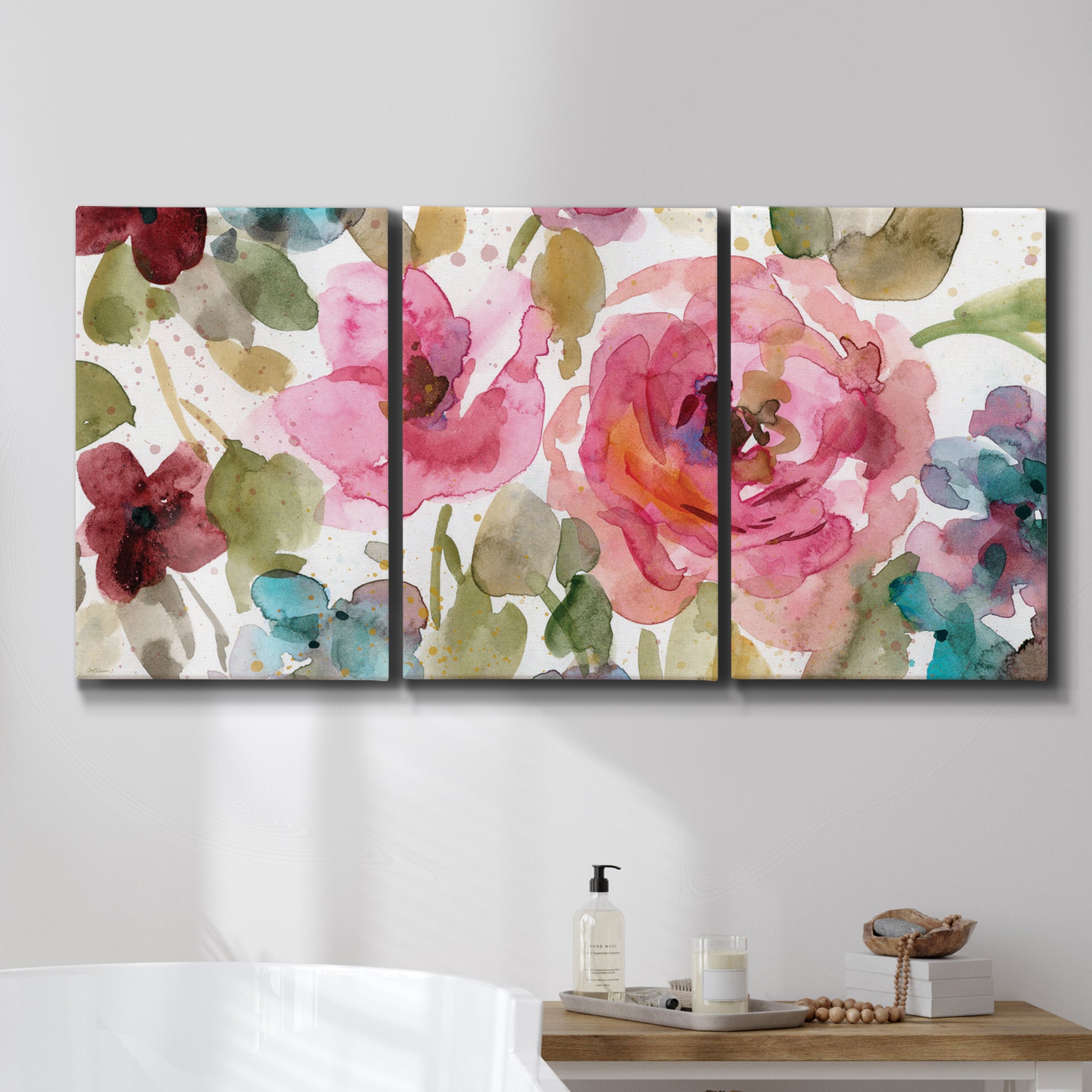 Three-panel canvas wall art featuring colorful floral watercolor composition, displayed in a bathroom above a bathtub.