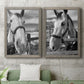 Set of two gray barnwood framed canvas prints depicting a coordinated art pair of black-and-white close-up portraits of horses at fences rendered as modern equestrian photography above a sofa in a modern living room.