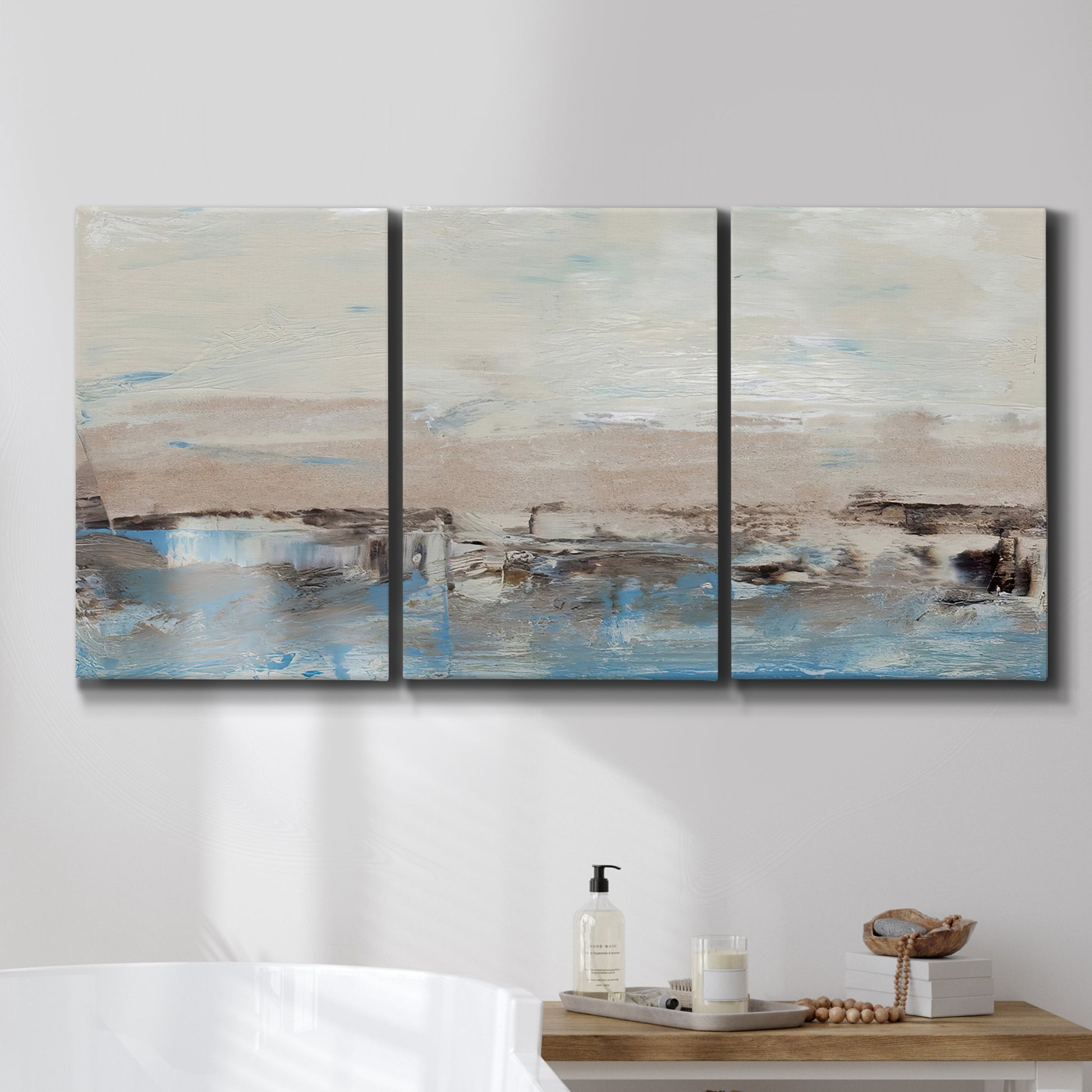 Three-panel canvas wall art featuring abstract bridge landscape in cyan, displayed in a bathroom above a bathtub.