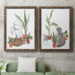 Set of two walnut barnwood framed canvas prints depicting a coordinated art pair of cats tucked among collections of potted houseplants rendered as whimsical botanical animal illustrations above a sofa in a modern living room.