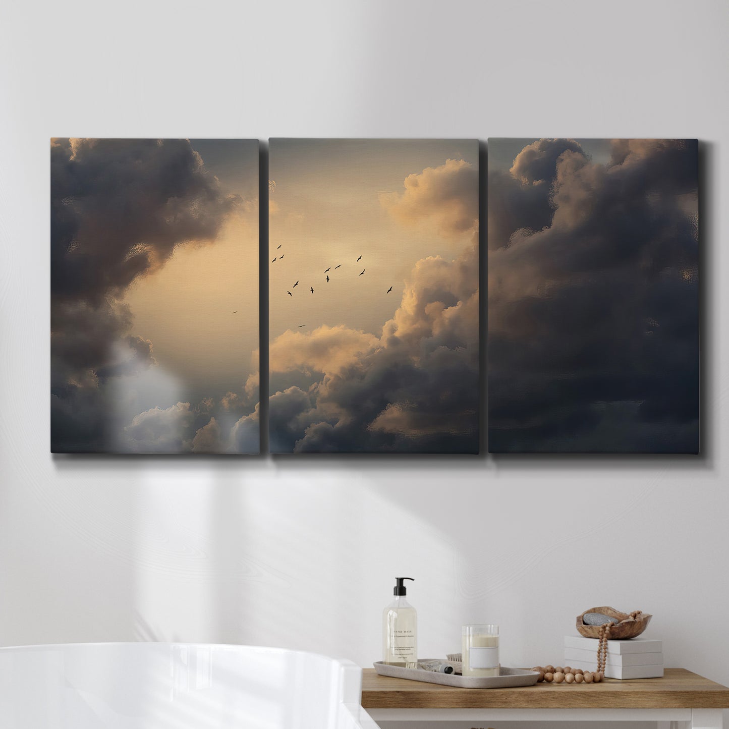 Three-panel canvas wall art featuring surreal floating figures above landscape, displayed in a bathroom above a bathtub.