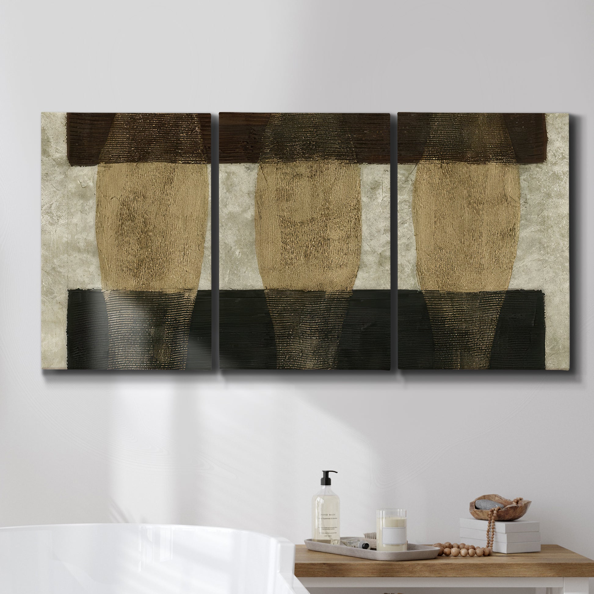 Three-panel canvas wall art featuring textured abstract vessel forms, displayed in a bathroom above a bathtub.