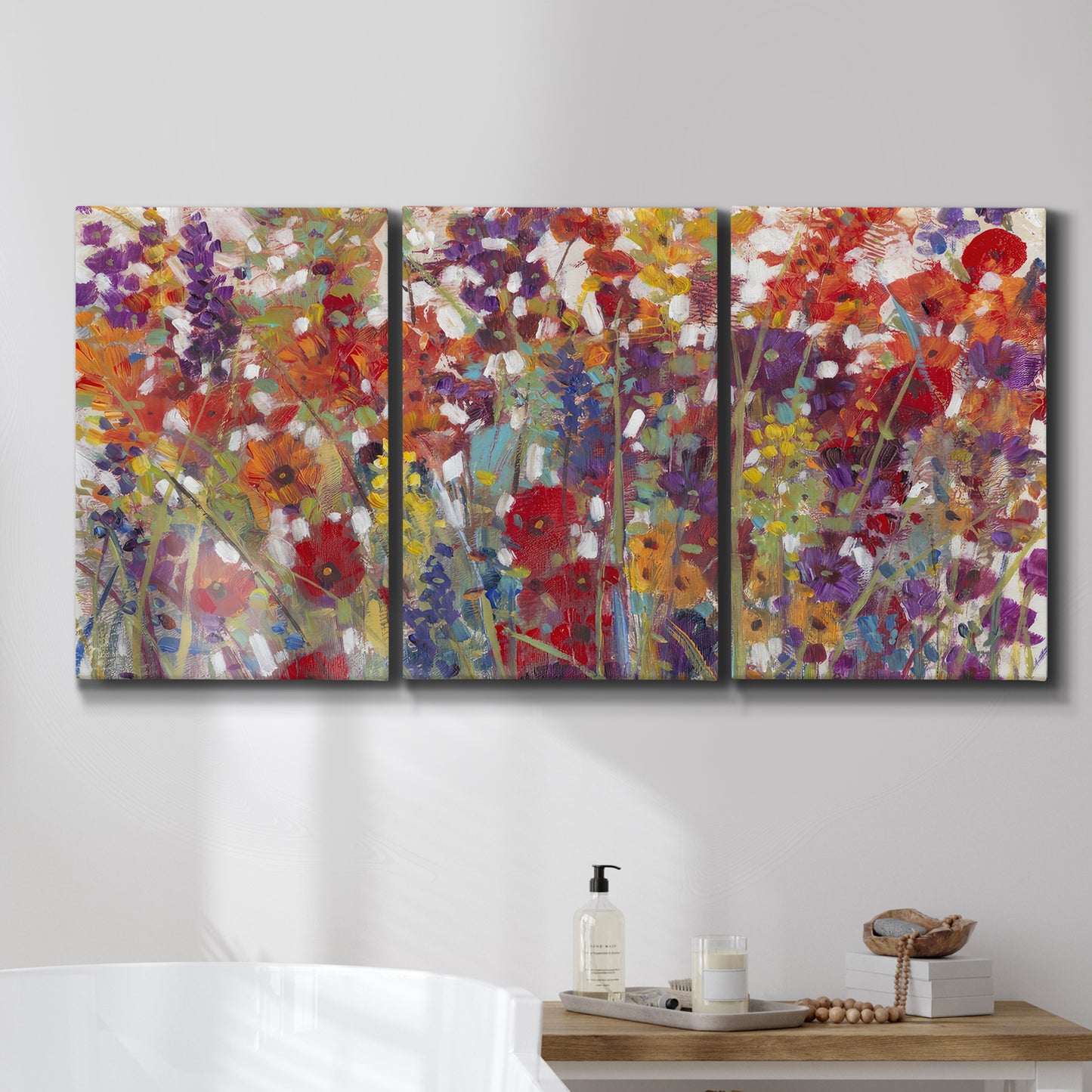Three-panel canvas wall art featuring colorful floral arrangement, displayed in a bathroom above a bathtub.