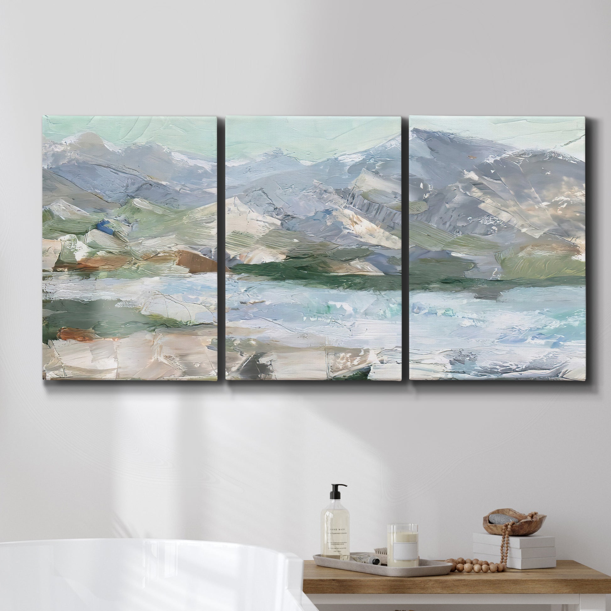 Three-panel canvas wall art featuring pastel mountain landscape view, displayed in a bathroom above a bathtub.