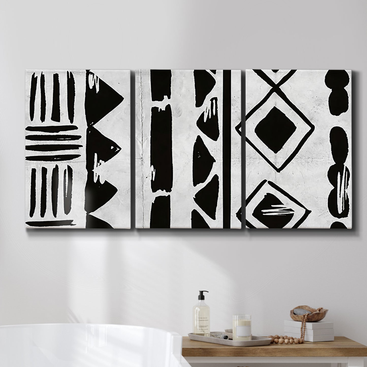 Three-panel canvas wall art featuring geometric abstract forms merging pattern, displayed in a bathroom above a bathtub.