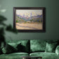 Impressionist valley landscape in southern France by Claude Monet in an ornate black frame with gilded inner detail displayed in a dark-toned interior setting.