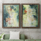 Set of two walnut barnwood framed canvas prints depicting a coordinated art pair of layered blue green cream and charcoal textures rendered as nature-inspired mixed-media abstracts above a sofa in a modern living room.