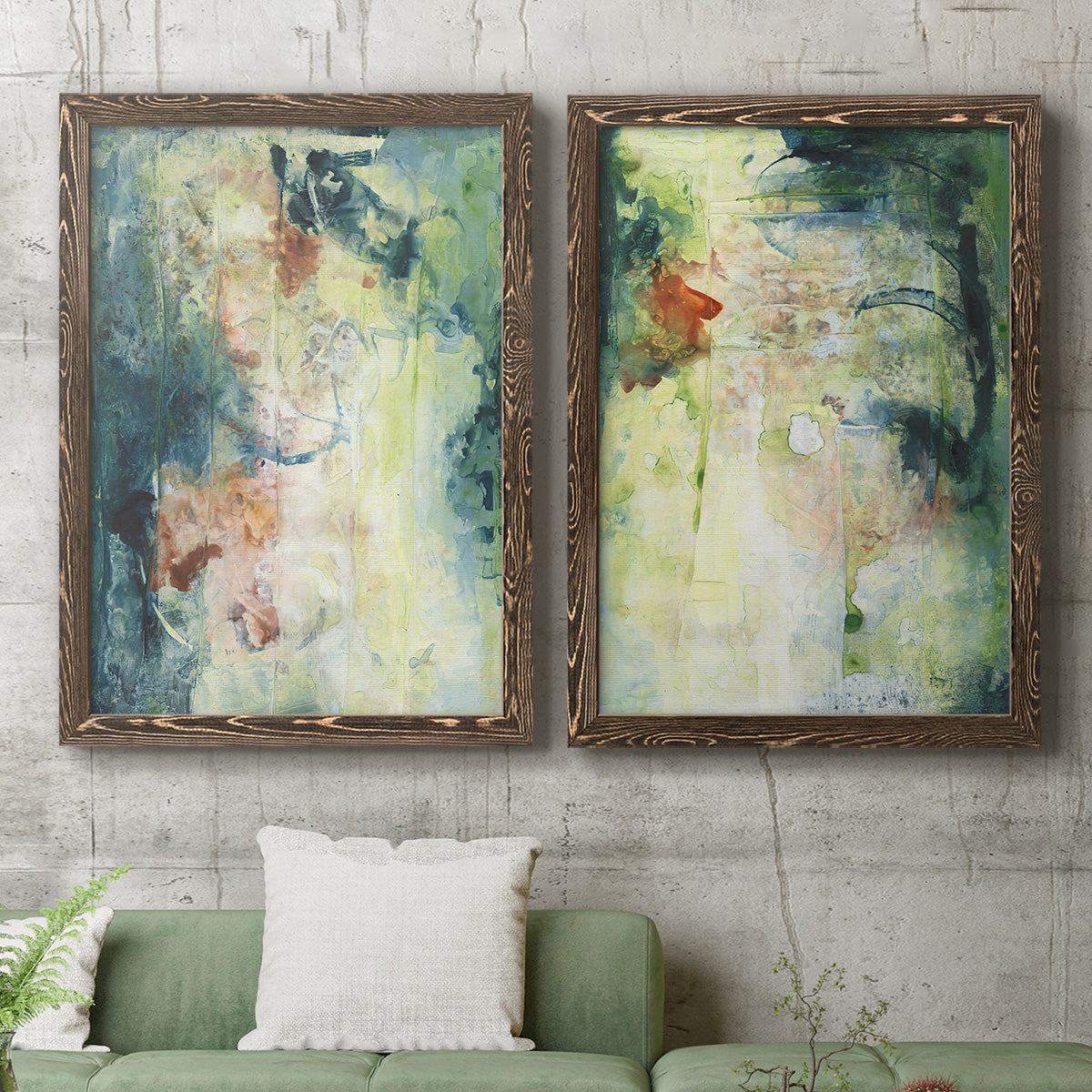 Set of two walnut barnwood framed canvas prints depicting a coordinated art pair of layered blue green cream and charcoal textures rendered as nature-inspired mixed-media abstracts above a sofa in a modern living room.