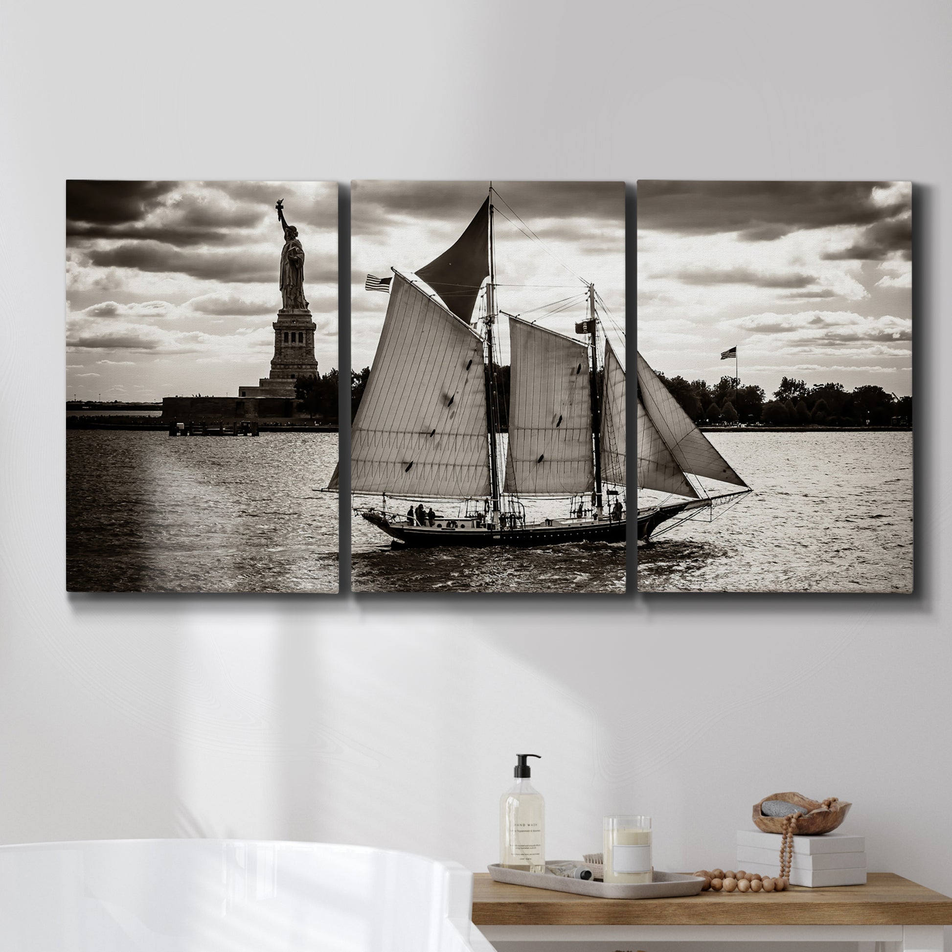 Three-panel canvas wall art featuring historic sailing ships photograph, displayed in a bathroom above a bathtub.
