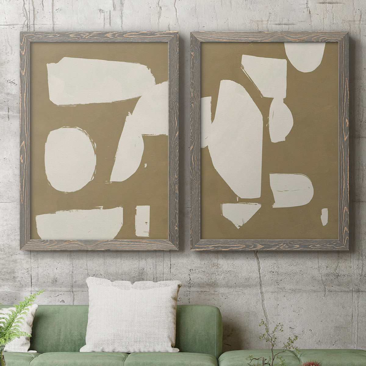 Set of two gray barnwood framed canvas prints depicting a coordinated art pair of irregular white cutout-like shapes on taupe grounds rendered as bold minimalist shape abstracts above a sofa in a modern living room.