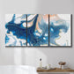 Three-panel canvas wall art featuring flowing blue abstract movement, displayed in a bathroom above a bathtub.