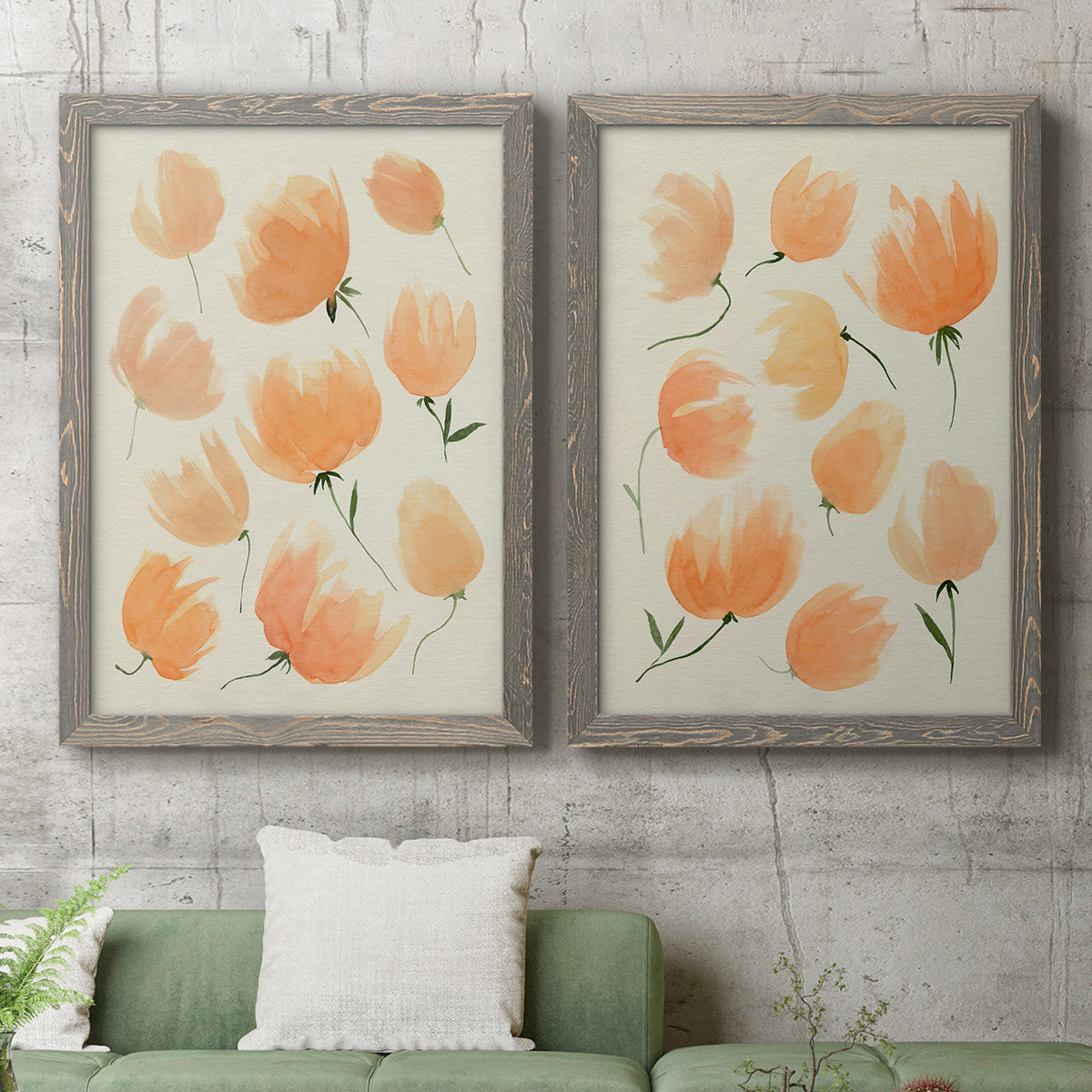 Set of two gray barnwood framed canvas prints depicting a coordinated art pair of loose peach-orange tulip-like blossoms rendered as airy watercolor floral paintings above a sofa in a modern living room.