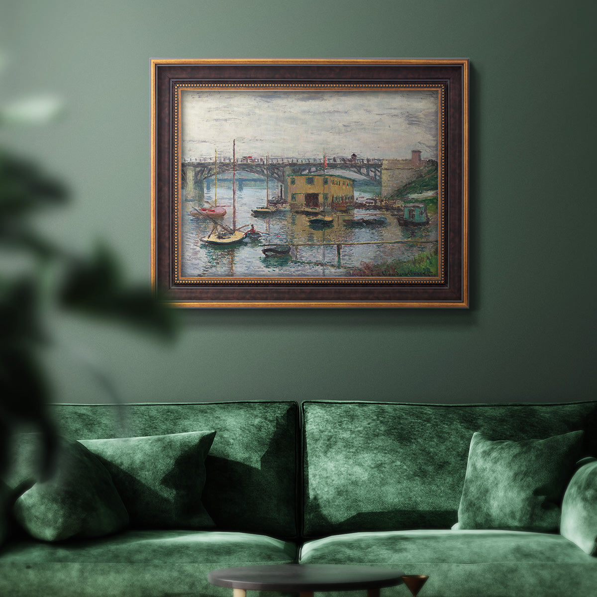 Impressionist river bridge scene on an overcast day by Claude Monet in an ornate bronzed mahogany wood frame displayed in a dark-toned interior setting.
