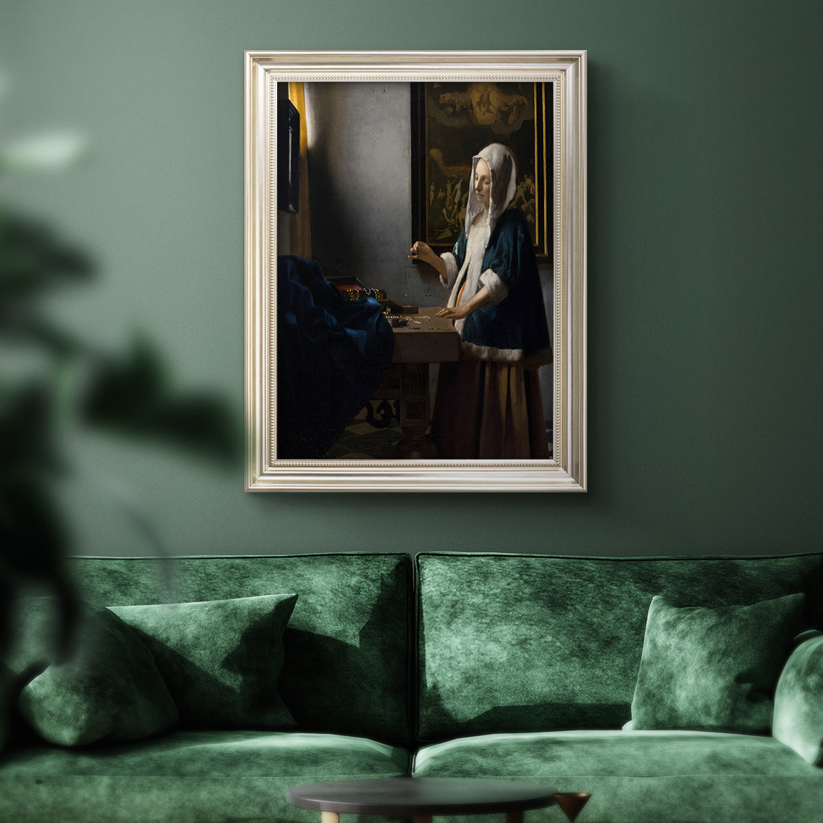 Quiet interior genre scene of a woman with scales by Johannes Vermeer in an ornate champagne frame displayed in a dark-toned interior setting.