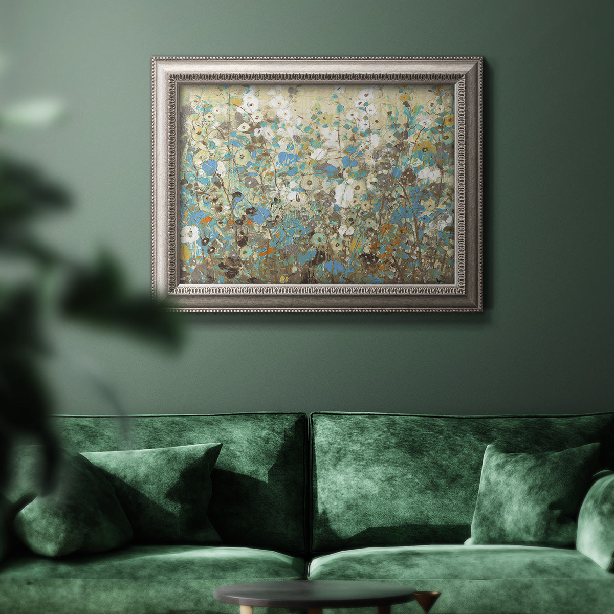 Impressionist flowering vine watercolor artwork in an ornate vintage silver frame displayed in a dark-toned interior setting.