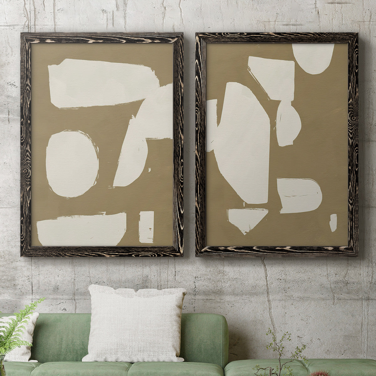 Set of two black barnwood framed canvas prints depicting a coordinated art pair of irregular white cutout-like shapes on taupe grounds rendered as bold minimalist shape abstracts above a sofa in a modern living room.