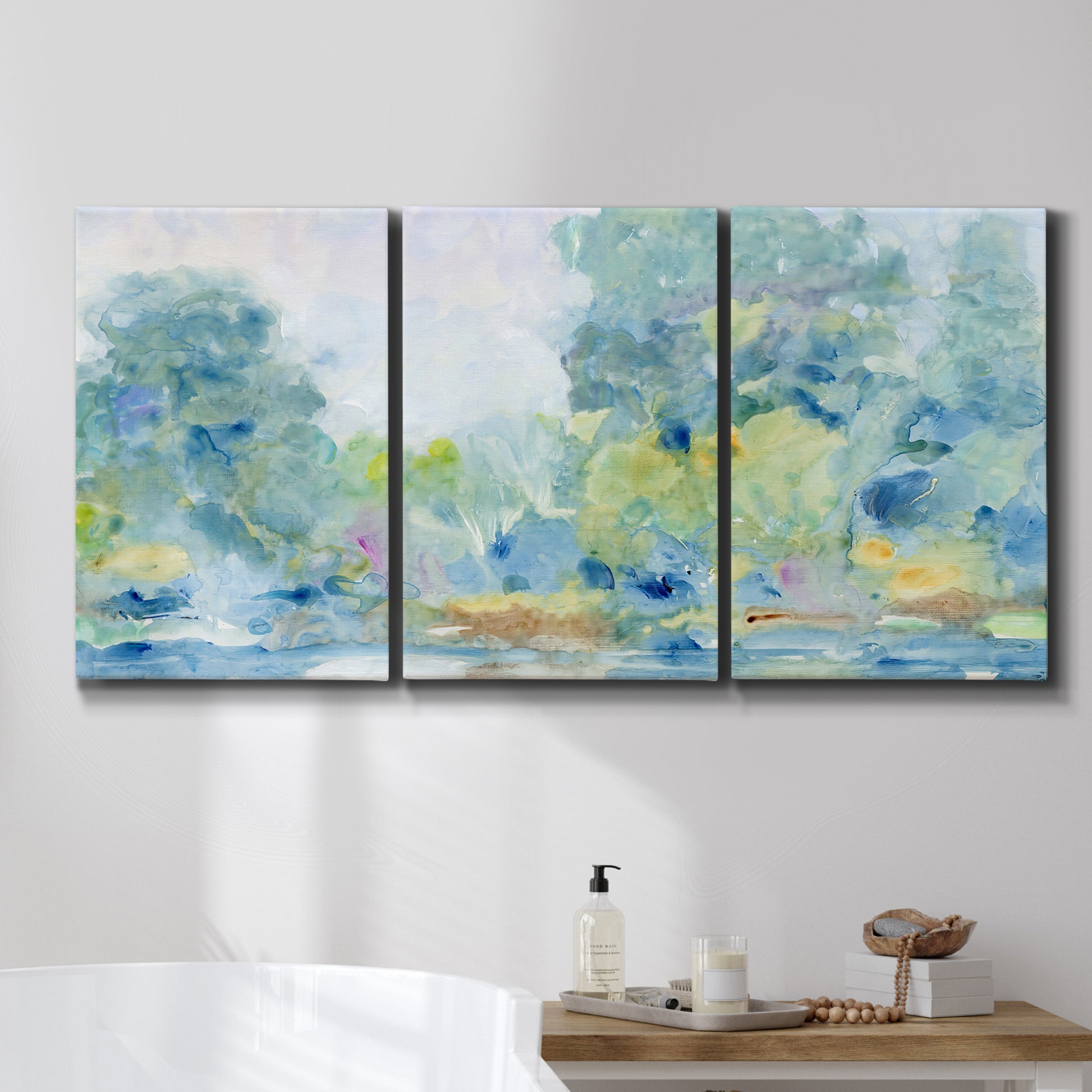 Three-panel canvas wall art featuring quiet abstract morning landscape, displayed in a bathroom above a bathtub.