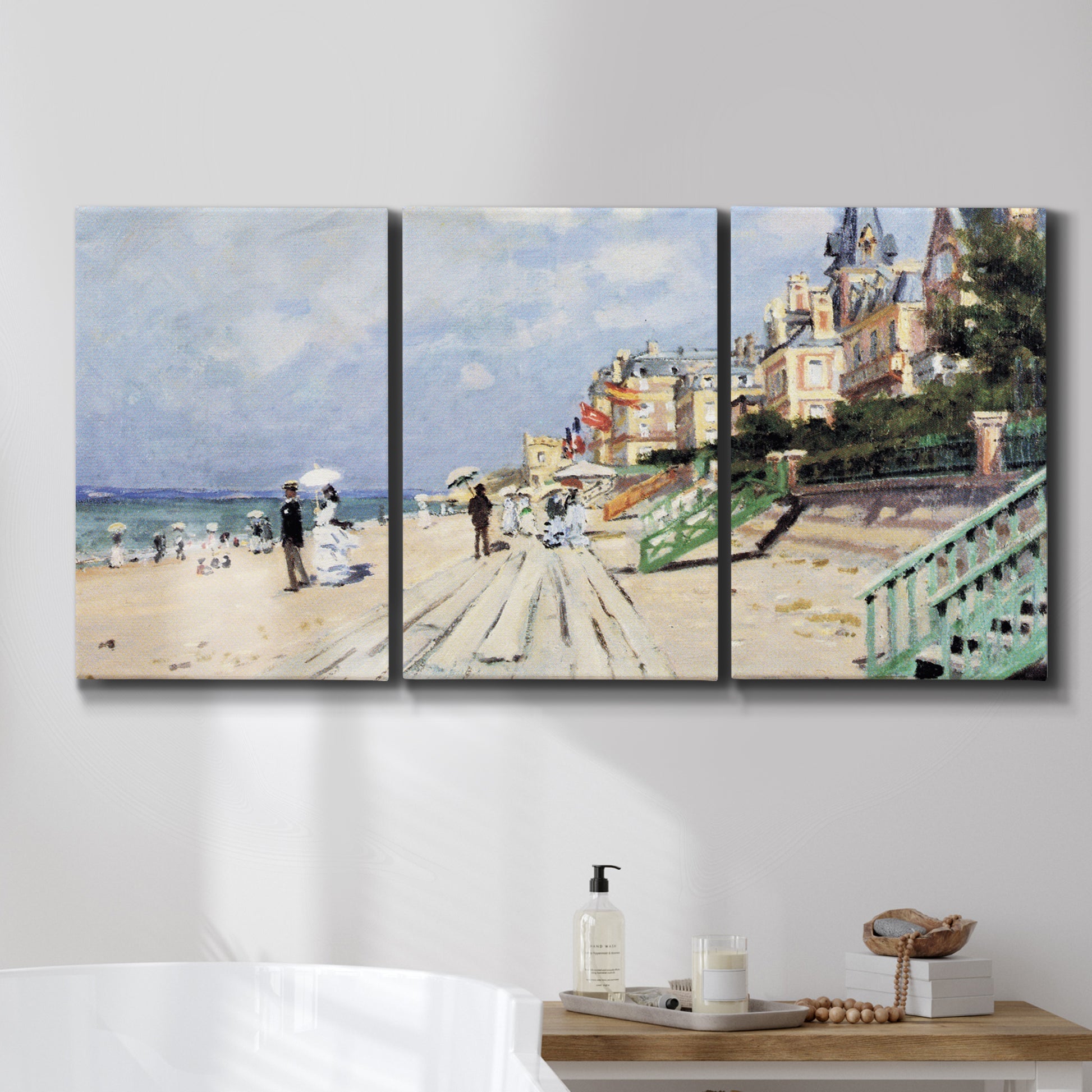 Three-panel canvas wall art featuring figures strolling along beach, displayed in a bathroom above a bathtub.