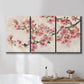 Three-panel canvas wall art featuring blooming cherry blossom branches, displayed in a bathroom above a bathtub.