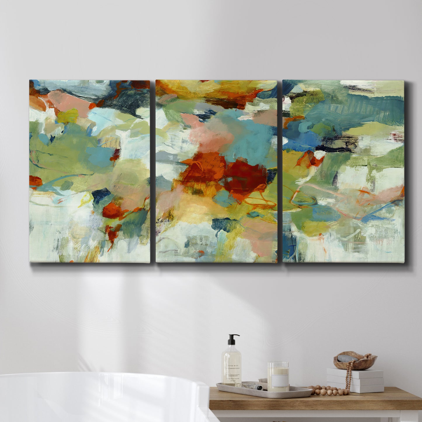 Three-panel canvas wall art featuring celebratory abstract color movement, displayed in a bathroom above a bathtub.