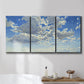Three-panel canvas wall art featuring whimsical cloud filled sky landscape, displayed in a bathroom above a bathtub.