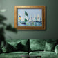 Coastal harbor watercolor painting in an ornate vintage gold frame displayed in a dark-toned interior setting.