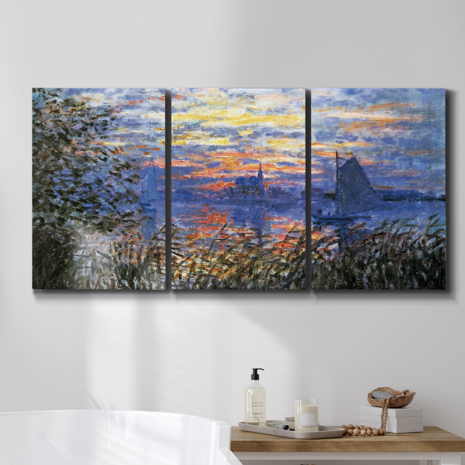 Three-panel canvas wall art featuring river sunset with reflections, displayed in a bathroom above a bathtub.