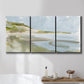 Three-panel canvas wall art featuring coastal cove with calm water, displayed in a bathroom above a bathtub.