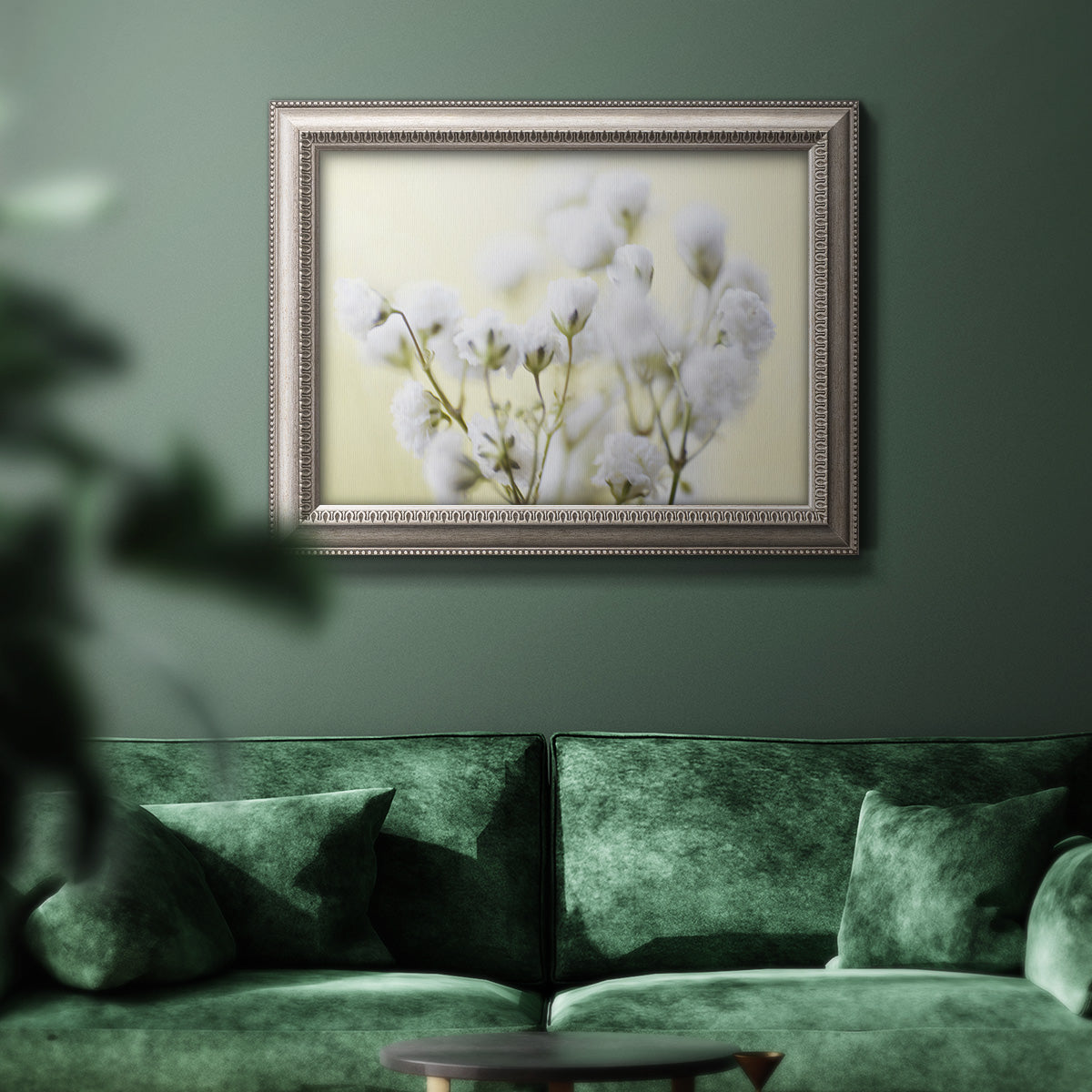 Soft-focus baby’s breath flower photograph in an ornate vintage silver frame displayed in a dark-toned interior setting.