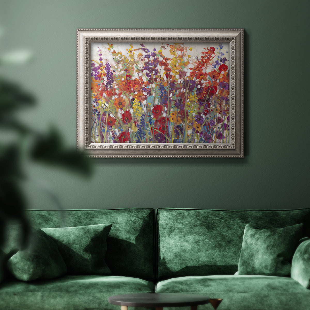 Impressionist floral bouquet artwork in an ornate vintage silver frame displayed in a dark-toned interior setting.