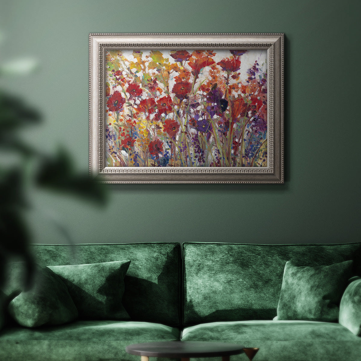 French country floral bouquet painting in an ornate vintage silver frame displayed in a dark-toned interior setting.