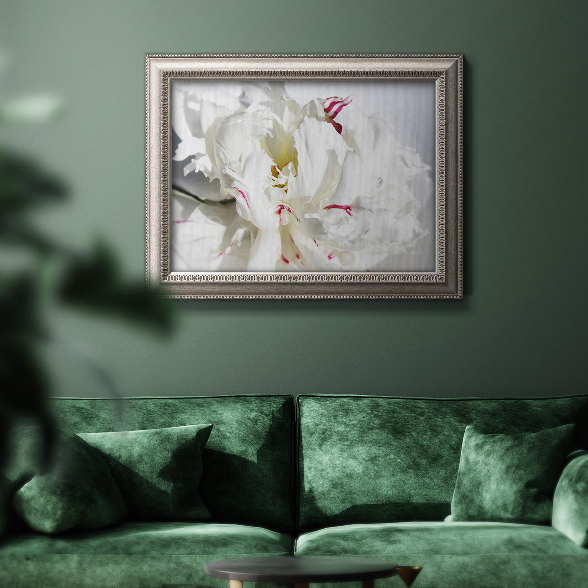 White peony close-up photography in an ornate vintage silver frame displayed in a dark-toned interior setting.