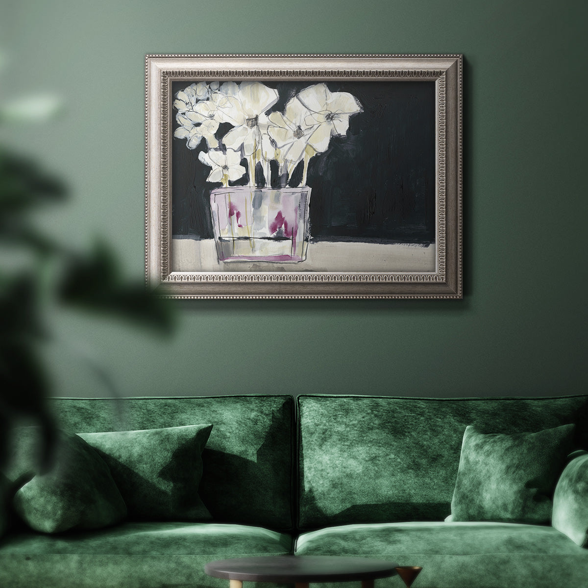 Contemporary floral watercolor with white flowers in an ornate vintage silver frame displayed in a dark-toned interior setting.