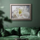 Soft white peony close-up in an ornate vintage silver frame displayed in a dark-toned interior setting.