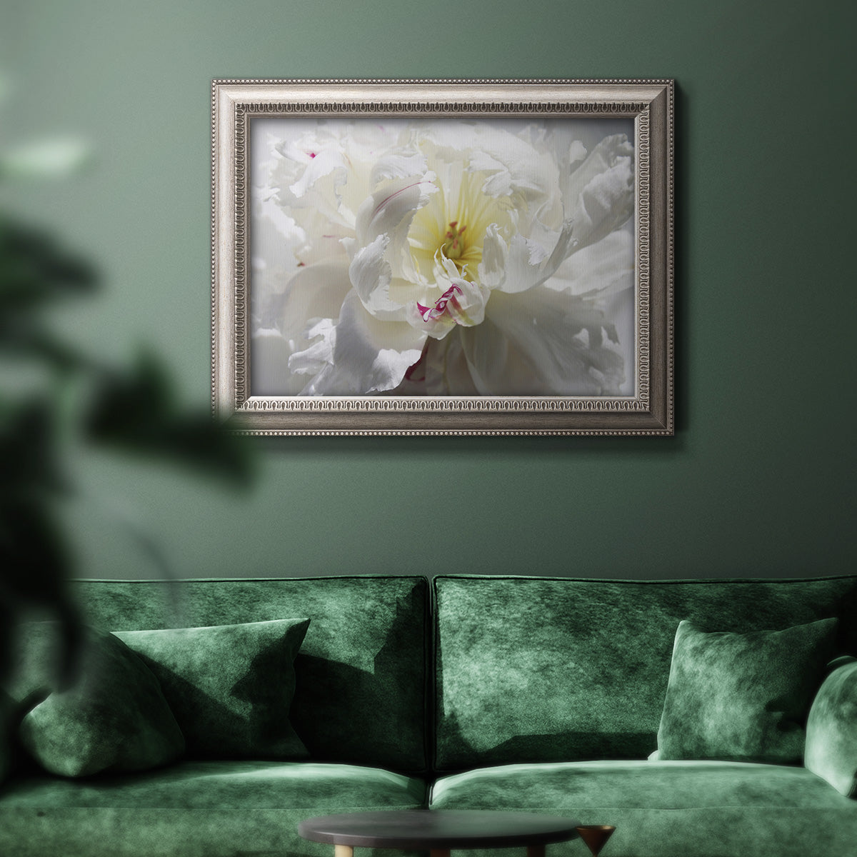 Neutral white peony photography in an ornate vintage silver frame displayed in a dark-toned interior setting.