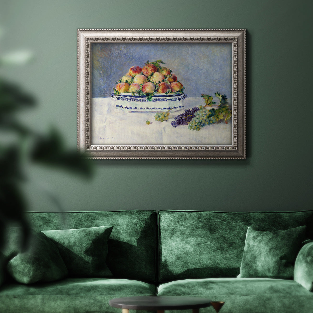 Impressionist still life painting with peaches and grapes in an ornate vintage silver frame displayed in a dark-toned interior setting.