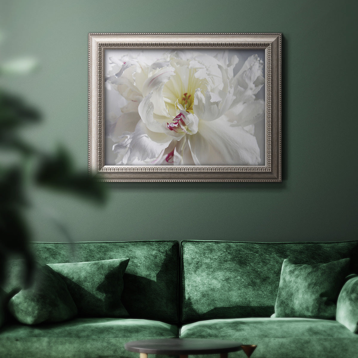 White floral photography close-up in an ornate vintage silver frame displayed in a dark-toned interior setting.