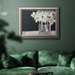 Modern abstract white floral watercolor artwork in an ornate vintage silver frame displayed in a dark-toned interior setting.